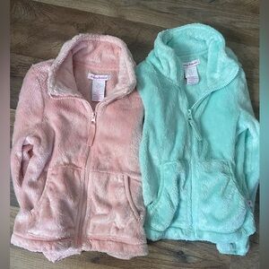 These are two size 6 girls zip up sweaters with pockets